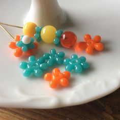 there are many beads on the plate and one is orange, blue, yellow and white