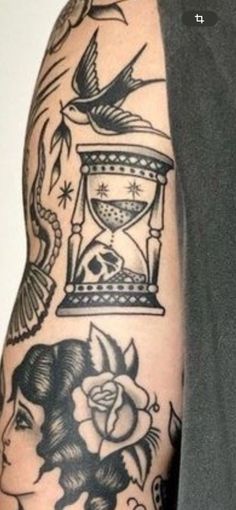 a man with tattoos on his arm has an hourglass and roses in front of him