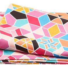 three different colored sheets stacked on top of each other, one with an abstract design