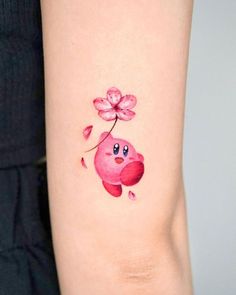 a watercolor tattoo with a pink flower on the arm