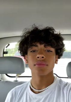 a young man sitting in the back seat of a car