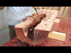 a man is cutting wood with a large knife