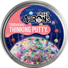 a tin filled with lots of different colored beads on top of a white surface and the words, crazy aarons thinking putty