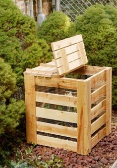 a wooden box sitting in the middle of some bushes