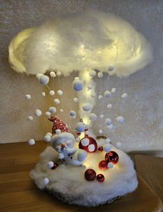 a white cloud filled with christmas decorations on top of a wooden table