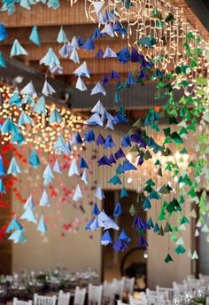 a room filled with lots of paper cranes hanging from the ceiling