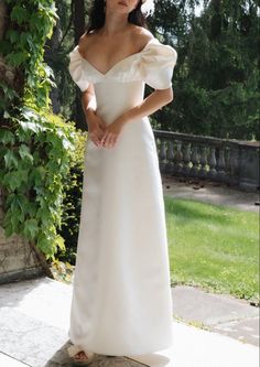 a woman in a white dress is posing for the camera with her hands on her hips