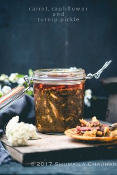 a jar filled with food sitting on top of a wooden cutting board