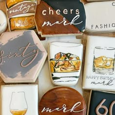 decorated cookies are arranged on a table with wine glasses and cheers mark written on them