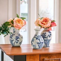 two blue and white vases with flowers in them