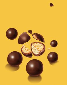 an image of some chocolate eggs on a yellow background with one broken and the other half eaten