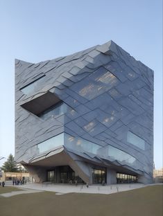 a large building with many windows and people walking around it