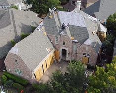 an aerial view of a large house with many windows and roofing materials on it