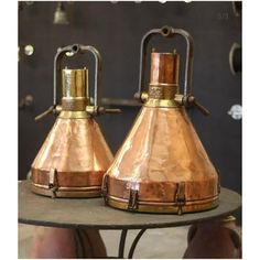 two copper colored lamps sitting on top of a table