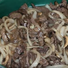 a pot filled with meat and onions on top of a stove