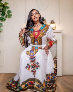 This Habesha dress is a true masterpiece, made of soft and luxurious Menen fabric combined with durable and breathable Shimena fabric. The lower part of the dress is made of Shimena fabric, known for its durability and softness, while the upper part of the dress is adorned with intricate Tilf embroidery, featuring delicate patterns and designs that are unique to Ethiopian traditional clothing. The dress is designed with a fitted bodice that accentuates the waistline and flares out into a full Sh Ethiopian Hair, Eritrean Dress, Habesha Dress, Ethiopian Traditional Dress, Ethiopian Dress, Habesha Kemis, Cultural Events, Traditional Clothing, Fitted Bodice