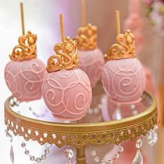 there are pink cake pops with gold decorations on them