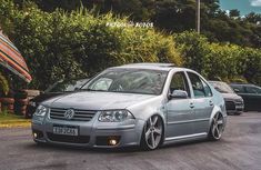 a silver car parked in front of some bushes