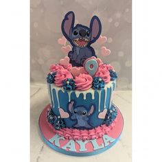 a blue and pink cake with an image of stitch on it