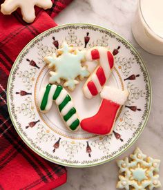 decorated cookies on a plate next to christmas decorations