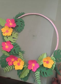 paper flowers and leaves are arranged on a circular wreath made out of pink, yellow and green paper