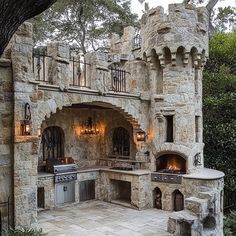 an outdoor kitchen is built into the side of a castle like building with stone walls