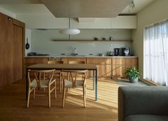 an open kitchen and dining room with wood flooring is seen in this image from the living room