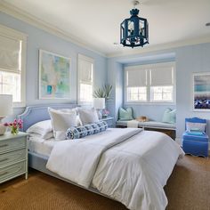 a bedroom with blue walls and white bedding