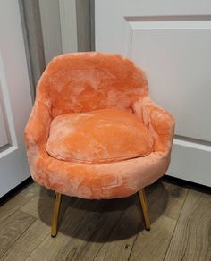 an orange chair sitting in front of a door