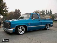 a blue pick up truck parked in a driveway