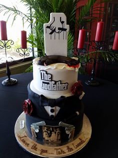 a three tiered cake on a table with red candles