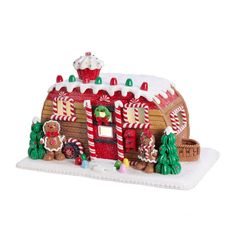 a christmas scene with a small house made out of gingerbreads and candy canes