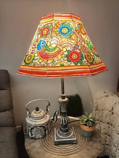 a lamp that is sitting on top of a table next to a potted plant