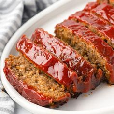 slices of meatloaf on a plate with ketchup spread over the top