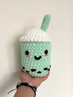 a crocheted cup holder with a green coffee cup in the shape of a kawaimika