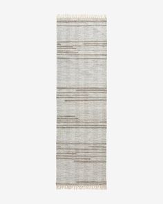 a gray and white striped rug with fringes on the bottom, in front of a white background