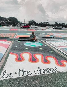 a person sitting on the ground in front of chalk art