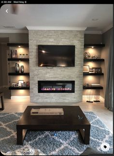 a living room with a large fireplace and built - in shelving units on the wall