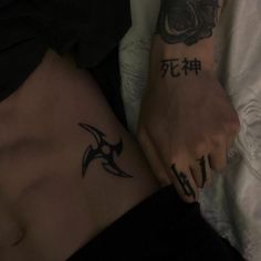 two people with tattoos on their stomachs and one is holding the other's hand