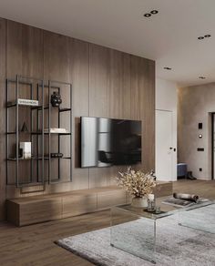 a modern living room with wood paneling and glass coffee table in front of the tv