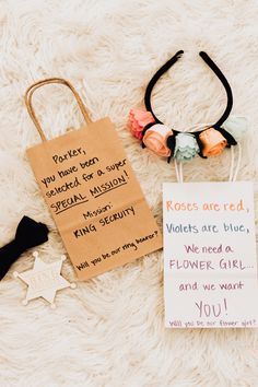 two pieces of paper with writing on them sitting on top of a white rug next to a bag