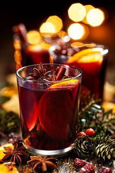 two glasses of mulled tea with orange slices and spices