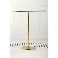 a gold metal stand on a black and white tile floor