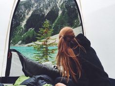 a woman is sitting in the back of a tent