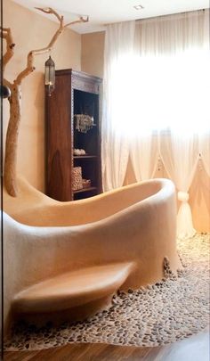 a bath tub sitting in the middle of a living room next to a wooden cabinet