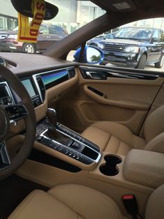 the interior of a car with beige leather seats and dashboard controls, including an automatic steering wheel