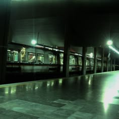 an empty subway station at night with the lights on