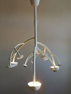 a white chandelier with three lights hanging from it