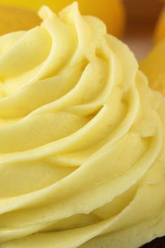 a close up view of yellow frosting on a cupcake