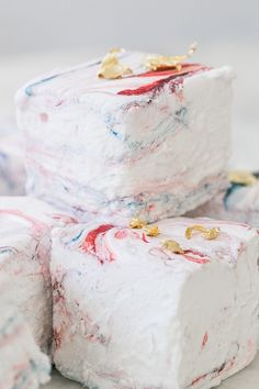 three pieces of white cake with red, blue and gold frosting on them sitting on a plate